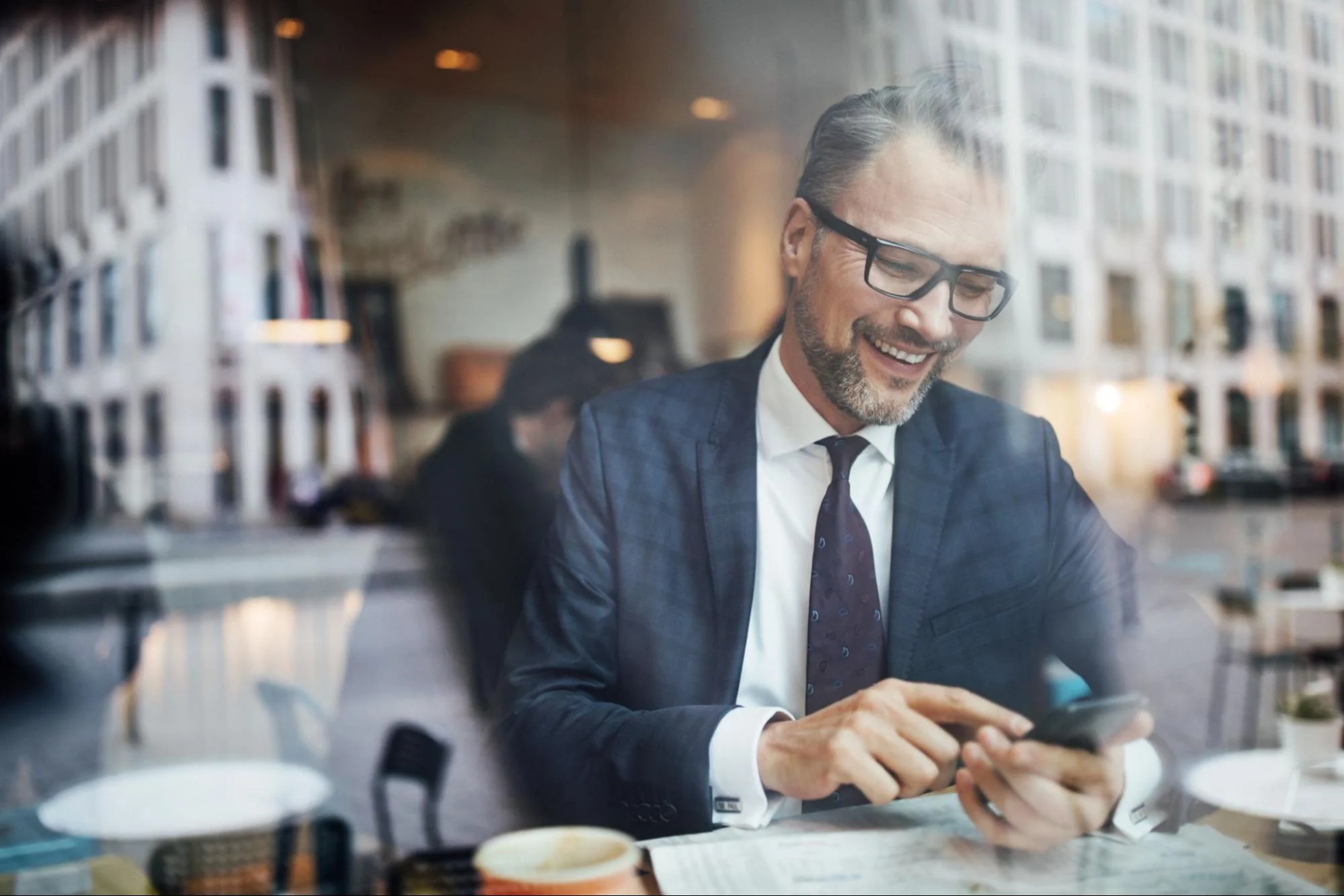 middle age man smiling while looking at the phone