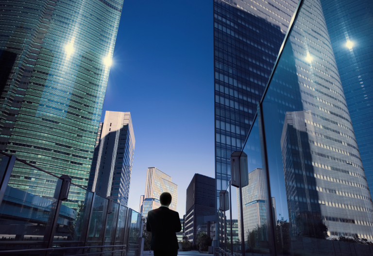 Businessman standing in front of multiple office buildings