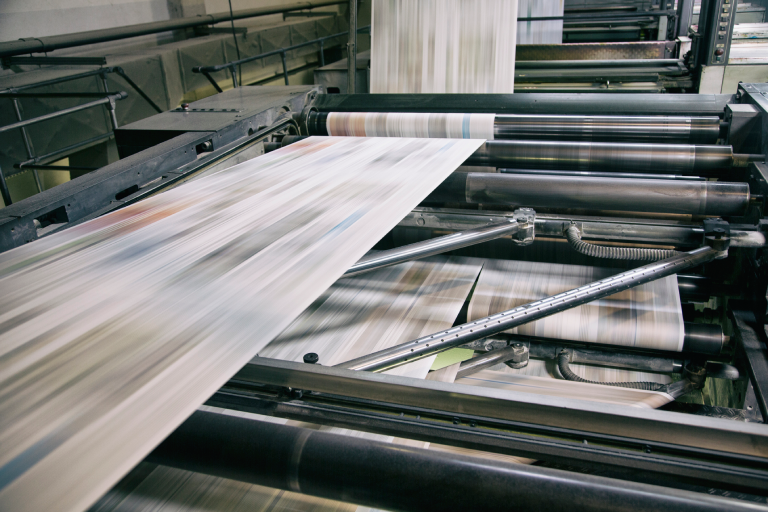 Newspaper being printed on a printing press