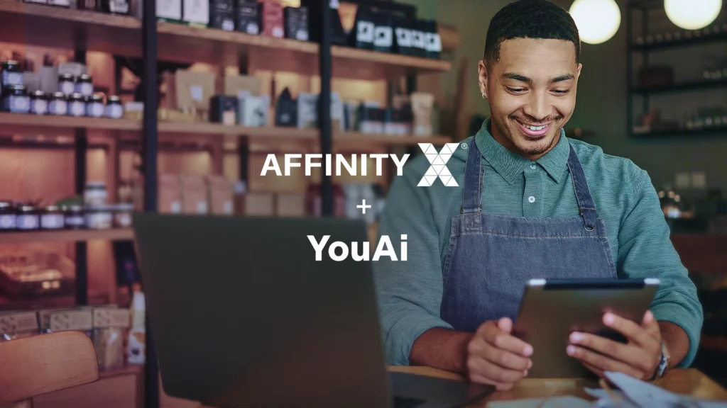 An image of a business owner using smart devices inside his shop commemorating the partnership between AffinityX and You AI